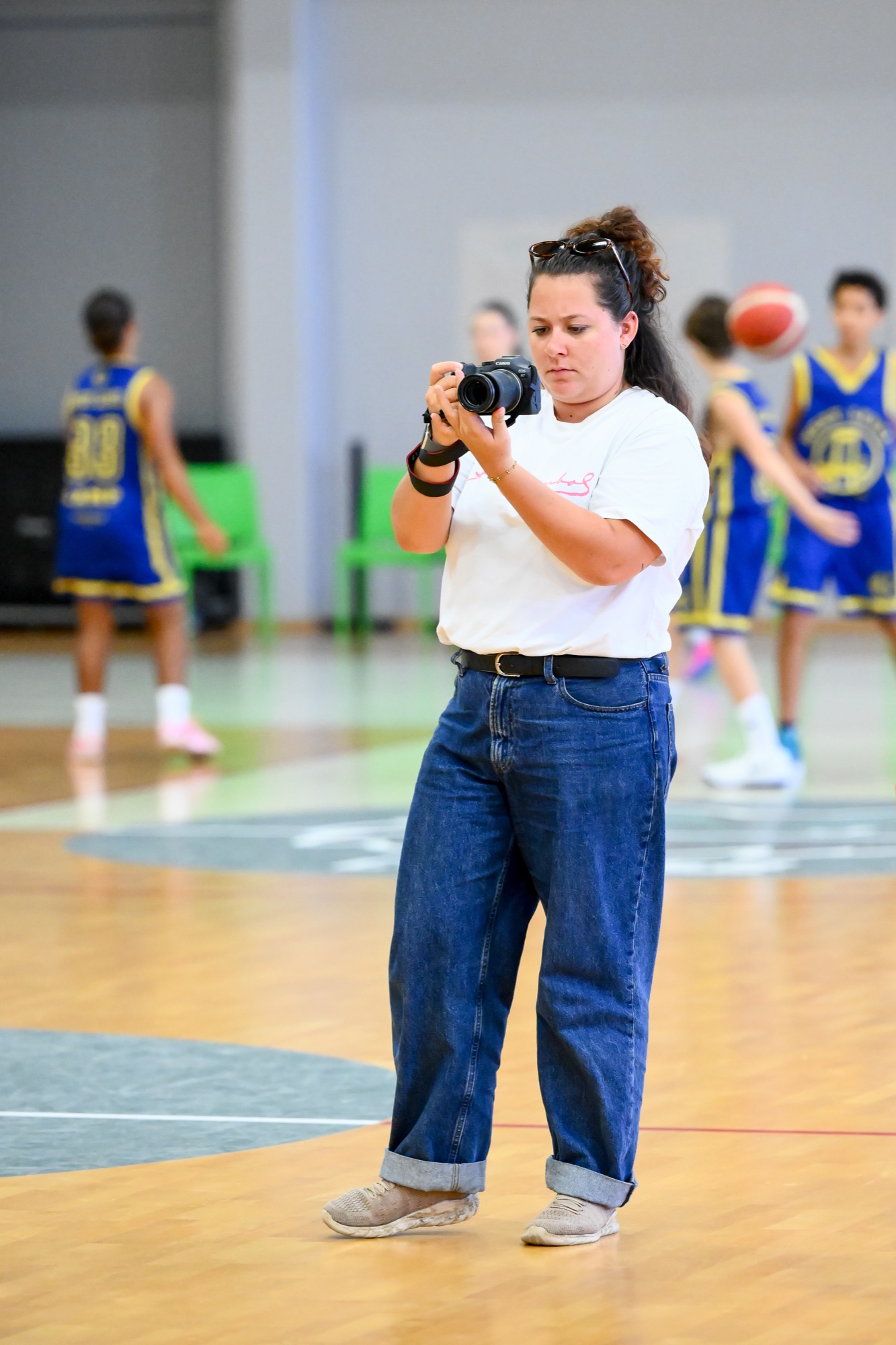 Maëlys photographiant un match de basket, appareil à l'œil