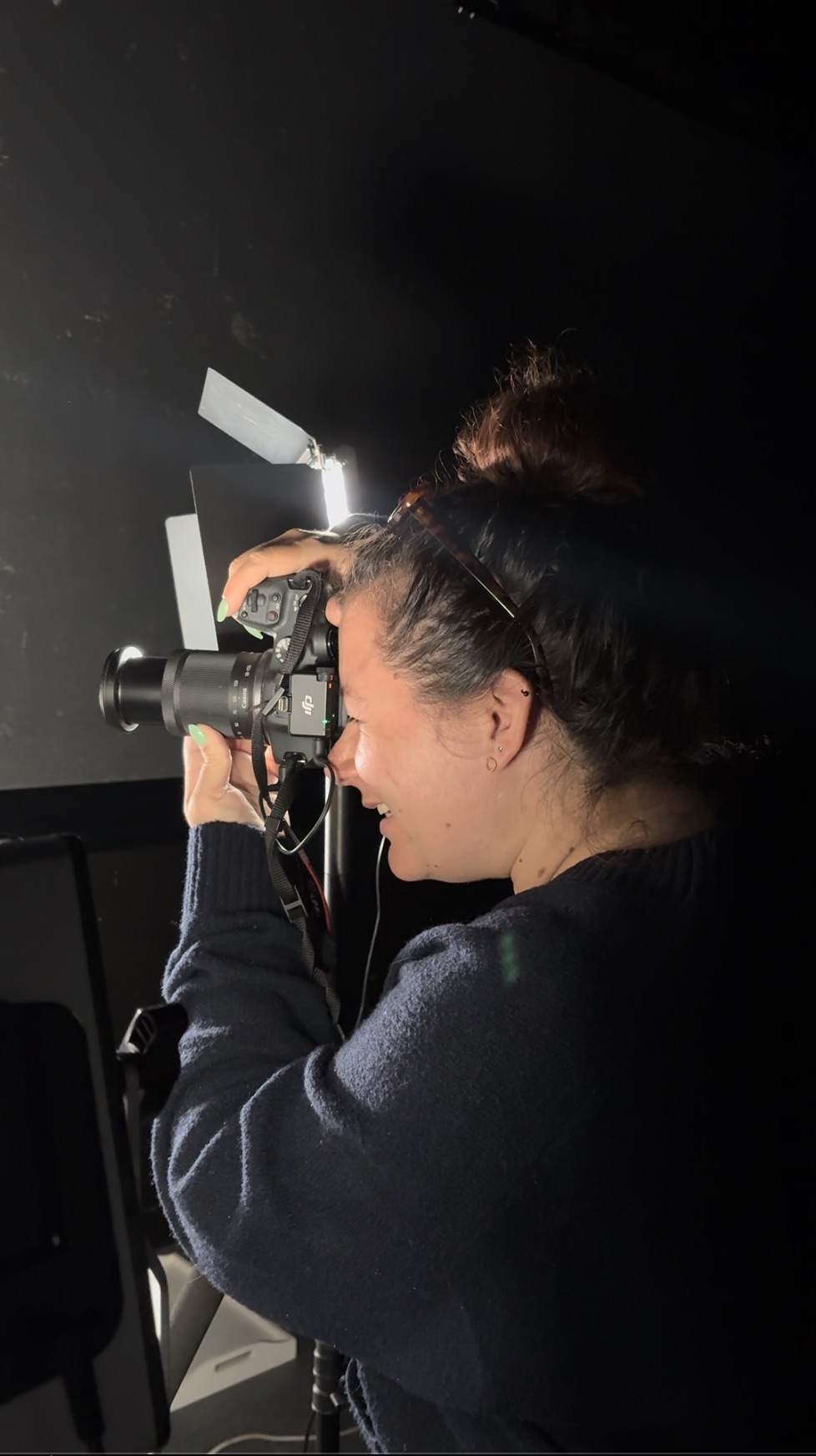 Maëlys en studio, réglant la lumière avant une prise de vue